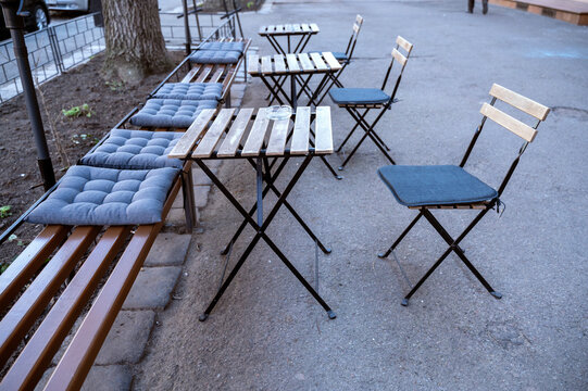 Outdoor seating area with tables and chairs in a row.