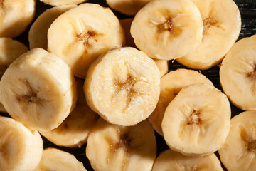 banana slices on black wood background top view