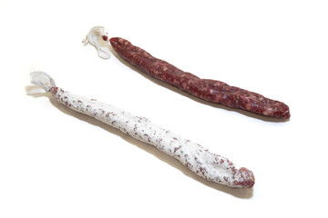 traditional Catalan fuet sausages on white background, one with a white moldy casing and one without (typical sausage from the northeast of Spain)