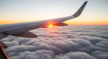 Obraz premium Airplane Wing Sunset Over Clouds During Flight in Bright Warm Light