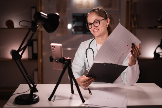 Young doctor recording video lesson using smartphone. Medic woman sharing medical knowledge online
