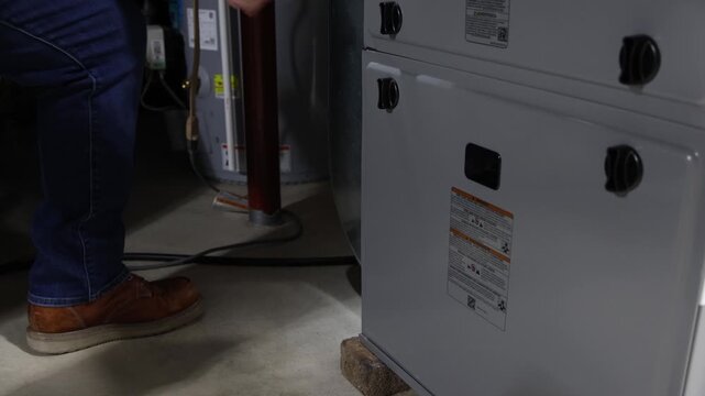 Handyman checking the filter on a home residential furnace.  