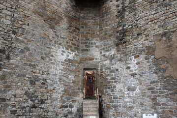 "Historic Guardtower Entrance with Rusted Door and Brick Walls