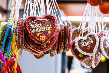 Close up of hanging gingerbread hearts with festive German greeting  “Frohes Weihnachten” (Merry Christmas)