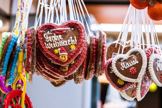 Close up of hanging gingerbread hearts with festive German greeting  “Frohes Weihnachten” (Merry Christmas) - Powered by Adobe