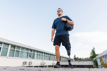 Fototapeta premium A man with disability is walking and exercising outdoors, showcasing his determination while using a prosthetic leg.