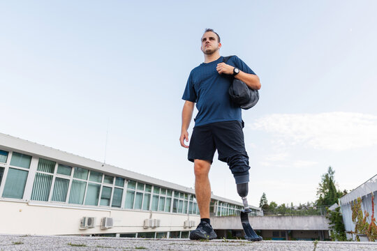 A man with disability is walking and exercising outdoors, showcasing his determination while using a prosthetic leg. - Powered by Adobe