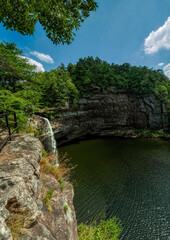 Fototapeta premium Experience the serene beauty of DeSoto Falls in Alabama under a clear blue sky