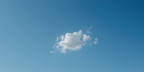 Single Fluffy Cloud Floating in a Brilliant Blue Sky