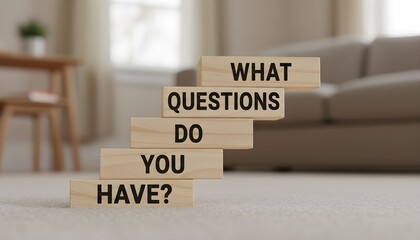Wooden blocks stacked in ascending order spelling out "What Questions Do You Have?".