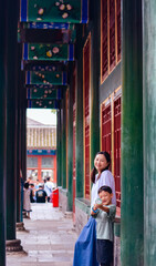Fototapeta premium Happy Asian mother and son posing playfully in front of traditional imperial house at Prince Gong's Mansion (Gongwangfu) in Beijing, China