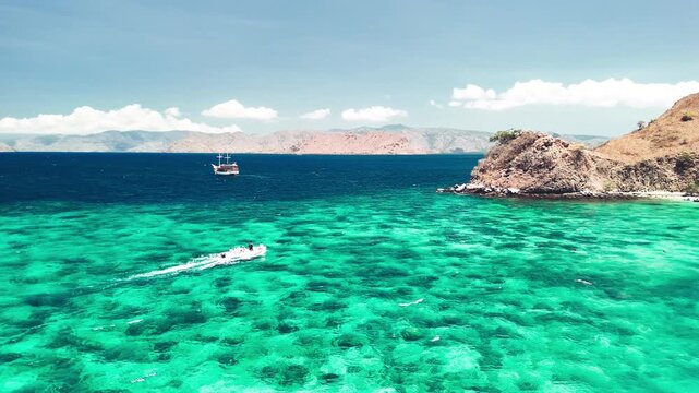Drone panorama of Komodo Pink Beach showing crystal clear turquoise waters and tropical shoreline