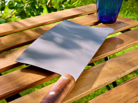 Hackmesser als Dekotablett auf Gartentisch in Garten