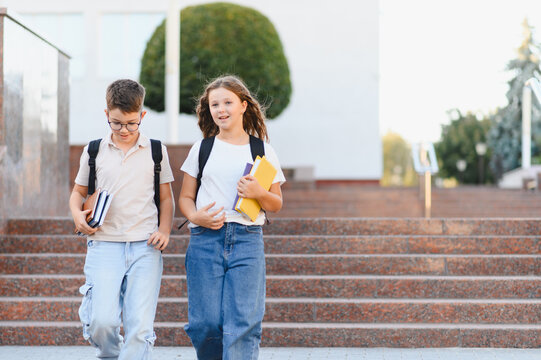 Students walking down school stairs carrying books