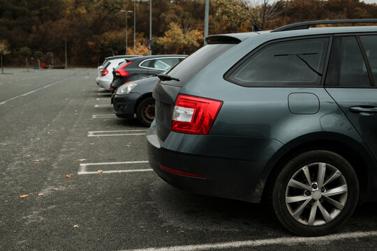 Row of parked vehicles in an outdoor parking lot on a cloudy day. The concept conveys daily routine, transport, and urban life