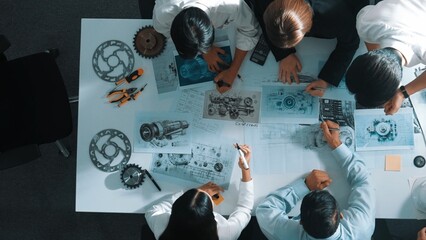 Top down view of skilled engineer showing and talking about turbine engine design. Aerial view of...