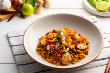 Tom Yum Fried Rice,Thai fried rice with shrimp and Straw mushroom with tom yum sauce in white plate.