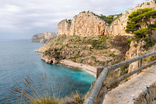 Seascape. Rocky cliffs with calm turquoise waters. Coastal landscape. Secluded bay with a beach surrounded by a vibrant sea. Nature concept.