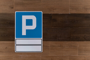 Znak parkingu na tle drewnianej ściany © Kacper