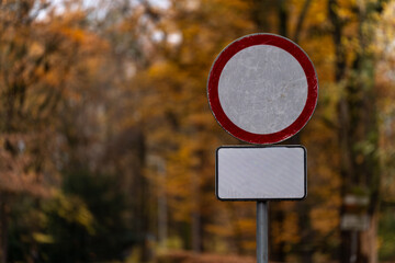 Znak zakazu wjazdu na tle jesiennego parku – koncepcja ograniczeń i przepisów ruchu drogowego
