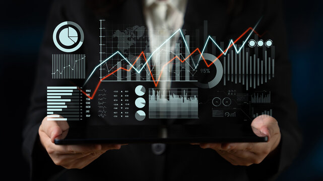 A business professional engages with digital financial data on a tablet, displaying various charts and graphs that illustrate key performance metrics and market trends. Scalp