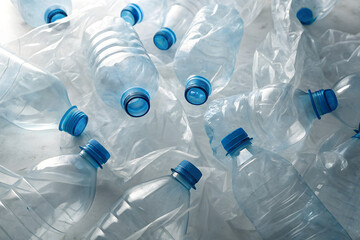 Pile of crumpled clear PET bottles with blue caps