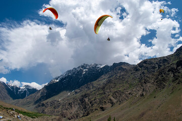 Tourists paragliding 3 pm 6 june 2025 at Leh Ladakh with view of Himalayan mountain range.