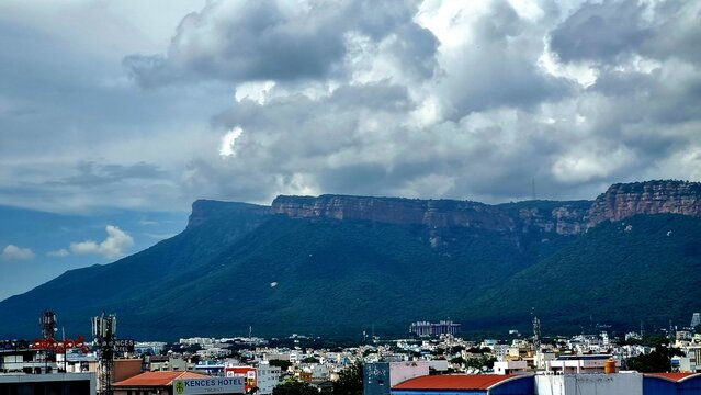 Tirupati, Andhra Pradesh, India - October 19, 2025: Skyline of Tirupati with the sacred Tirumala hill range rising behind the city, captured on a cloudy day with subtle monsoon light, layered terrain