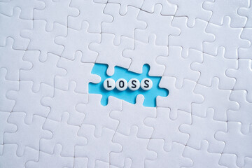 Loss text on light blue background with jigsaw puzzle