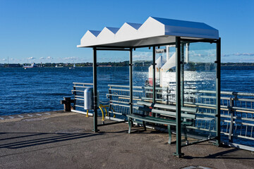Ferry terminal shelter at Kiel waterfront with benches and scenic Baltic Sea background