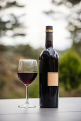 Bottle and glass of red wine on the table. Alcohol drink.