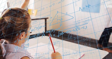Writing child in striped shirt solving math at classroom desk with red pencil, formulas, copy space