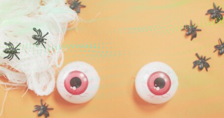 Showing white plastic eyes with pink irises veins on orange flat with spiders gauze turquoise dots