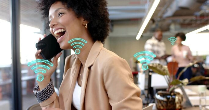 Laughing woman in beige blazer holding smartphone to ear at office, with turquoise Wi-Fi overlays