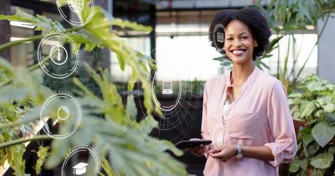 Smiling woman in pink blouse, watch, holding tablet amid pots, data icons in hothouse, copy space - Powered by Adobe