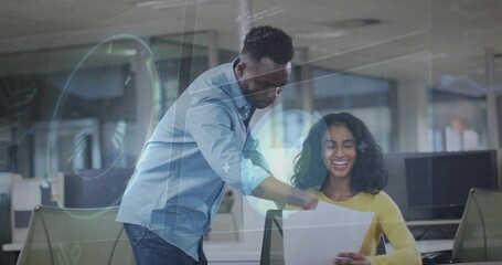 Pointing team wearing blue shirt and yellow sweater holding printout at office with digital overlay