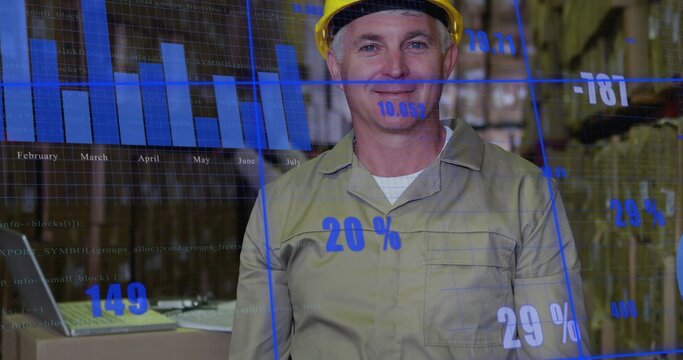 Standing warehouse lead in yellow hard hat and khaki shirt using laptop with blue data overlay - Powered by Adobe