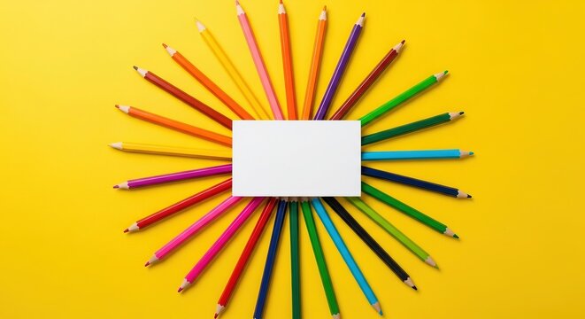 A sunburst of colorful pencils arranged around a blank white card on a vibrant yellow background, evoking creativity and art supplies - Powered by Adobe