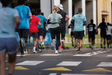diverse group of runners wearing colorful athletic clothing running in a marathon on city streets in Ljubljana
