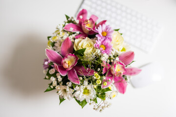 Bouquet of fresh pink and white flowers on white desk. Top view. Floral beauty, gentle composition, and creative workspace inspiration.