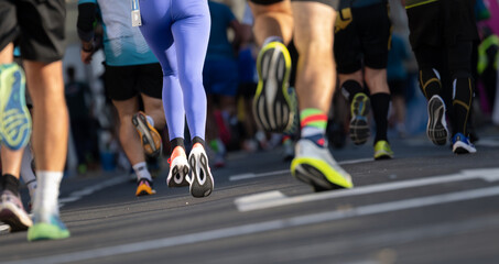 Marathon runners competing outdoors in Ljubljana with close up focus on their running shoes and legs