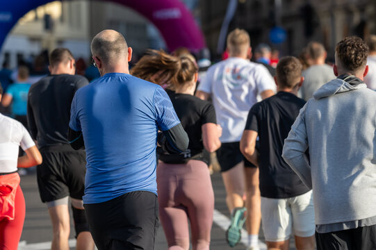Diverse group of runners competing in a marathon event in Ljubljana with close up views of athletes
