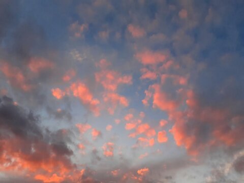 Cielo al tramonto con tante nuvolette colorate di rosa.