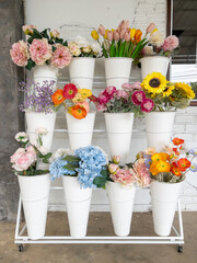 Vibrant Artificial Flowers Display on White Shelf.