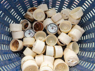 Old Water Meter Parts in Blue Basket for Repair.