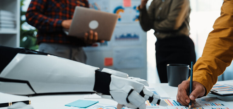 A human and a robot collaborate in a contemporary office setting. The scene highlights innovative teamwork and creative problem solving through technology, showcasing tools and ideas.Noogenesis