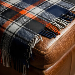 Plaid blanket on leather ottoman