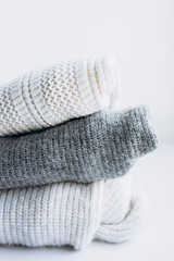 Close-up of a stack of pastel sweaters on a white background.