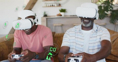 Father and adult son pressing controllers, playing VR game in home with green holograms appearing - Powered by Adobe