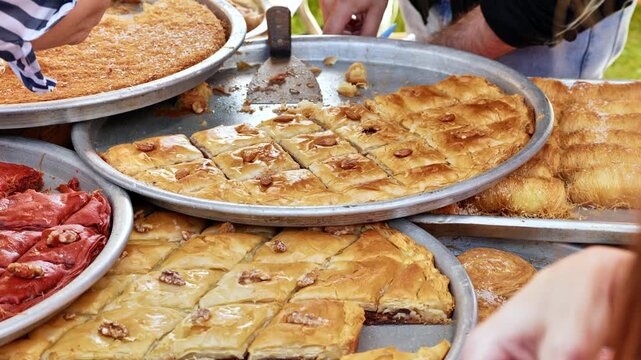 Assortment of sweet baklava and kadayif pastries at a street food market stall